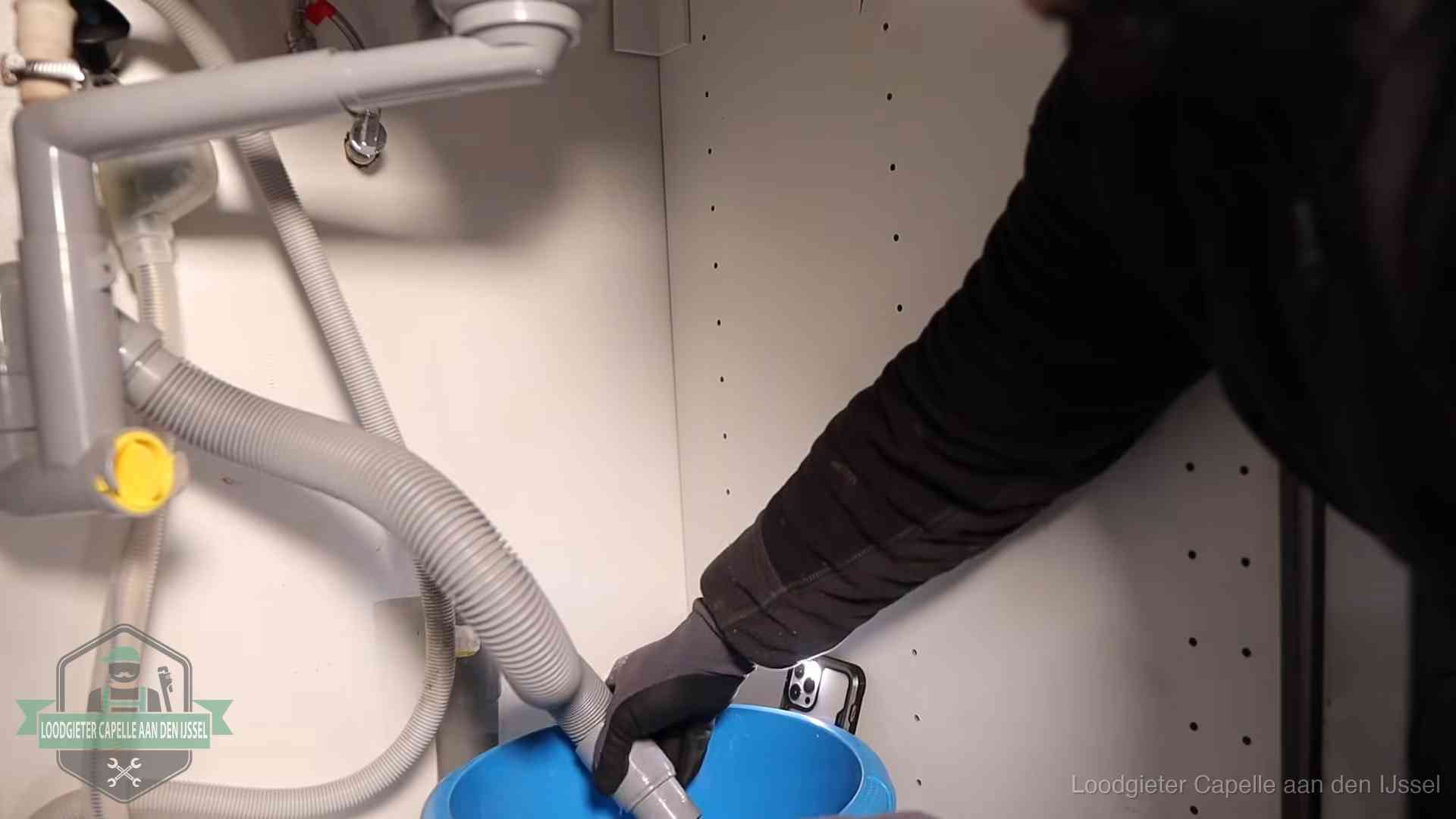 Afvoerslang loopt leeg in een emmer onder de gootsteen in Capelle aan den IJssel, een klus die je zelf kunt doen