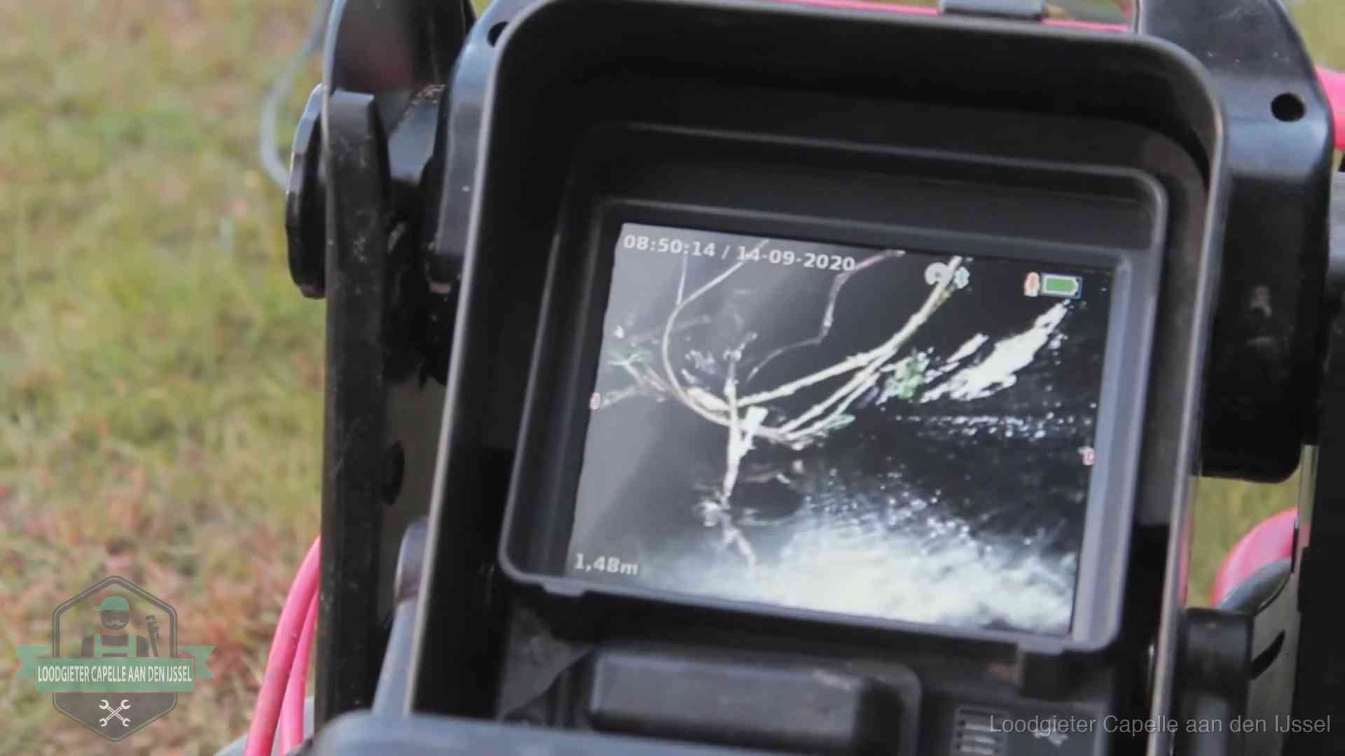 Monitor van een rioolcamera toont wortelingroei in de rioolbuis bij een woning in Capelle aan den IJssel