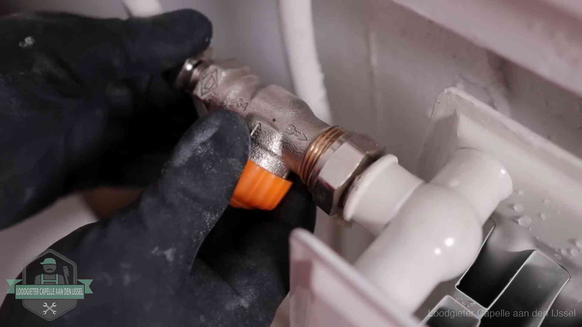 Thermostaatkraan wordt gemonteerd op een radiator in Capelle aan den IJssel voor het stookseizoen