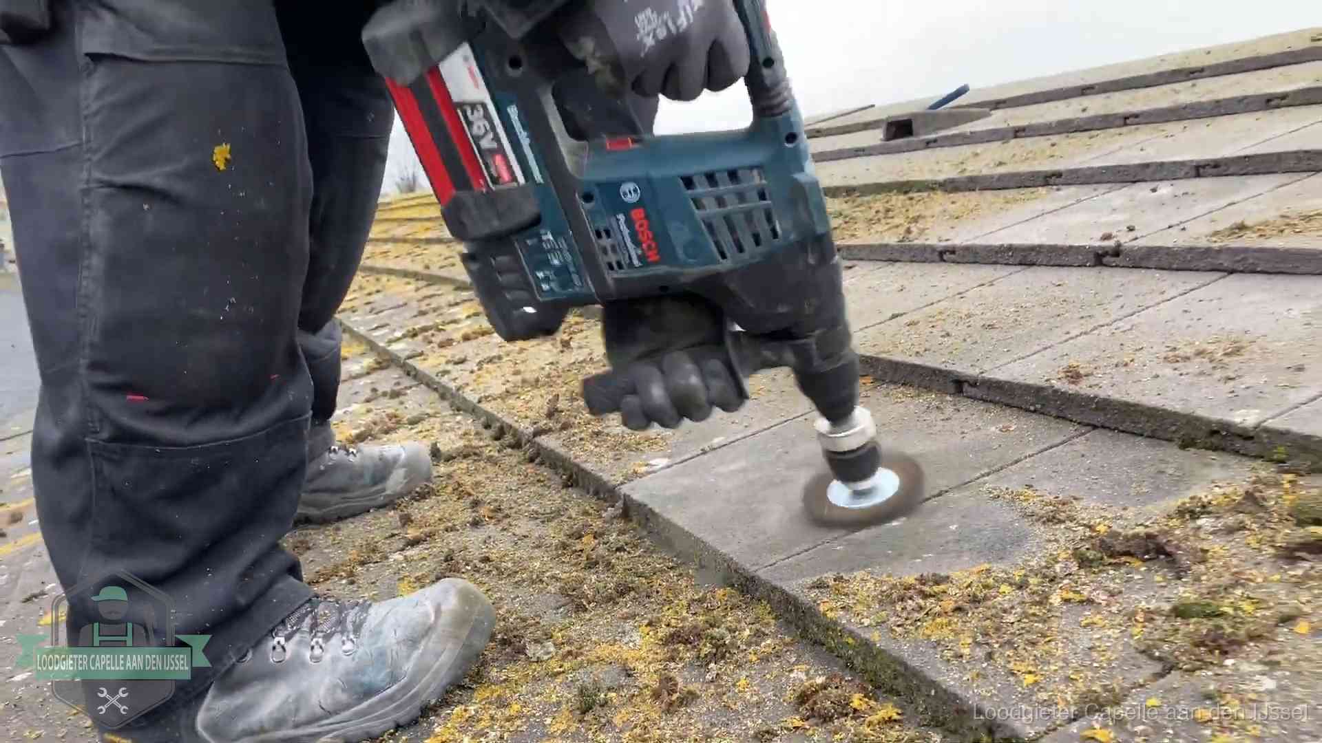 Betonnen dakpannen worden machinaal gereinigd tijdens dakonderhoud in Capelle aan den IJssel