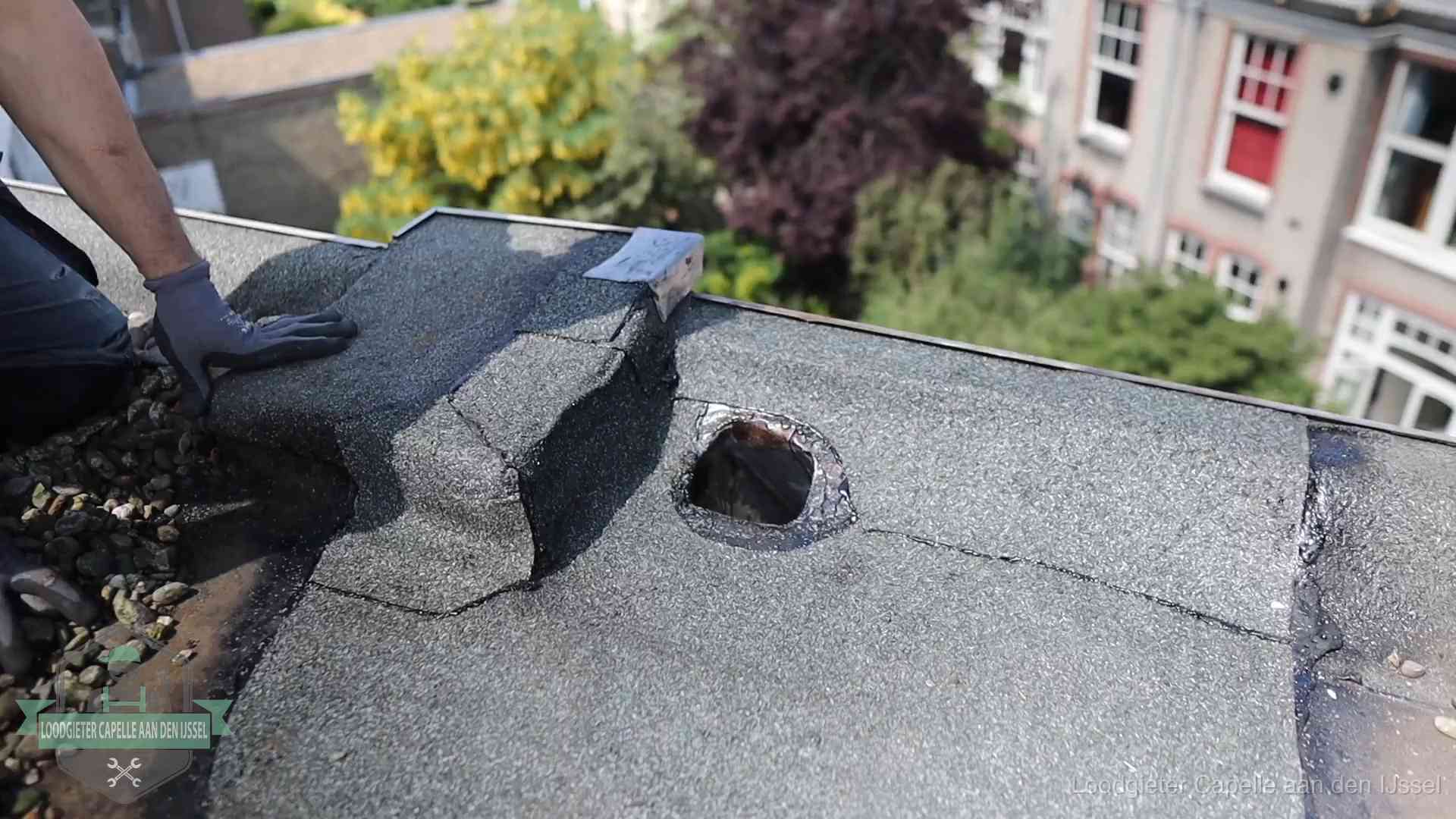 Loodgieter inspecteert een beschadigd bitumen plat dak tijdens een daklekkage-inspectie in Capelle aan den IJssel