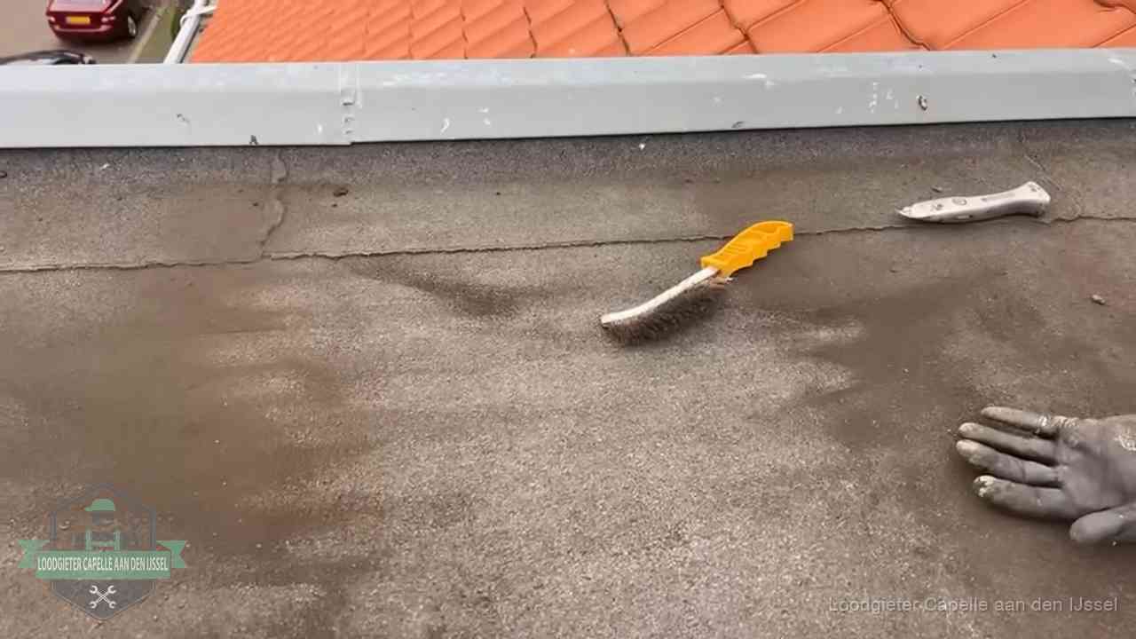 Dakdekker bereidt een bitumen plat dak voor op reparatie bij de daktrim in Capelle aan den IJssel