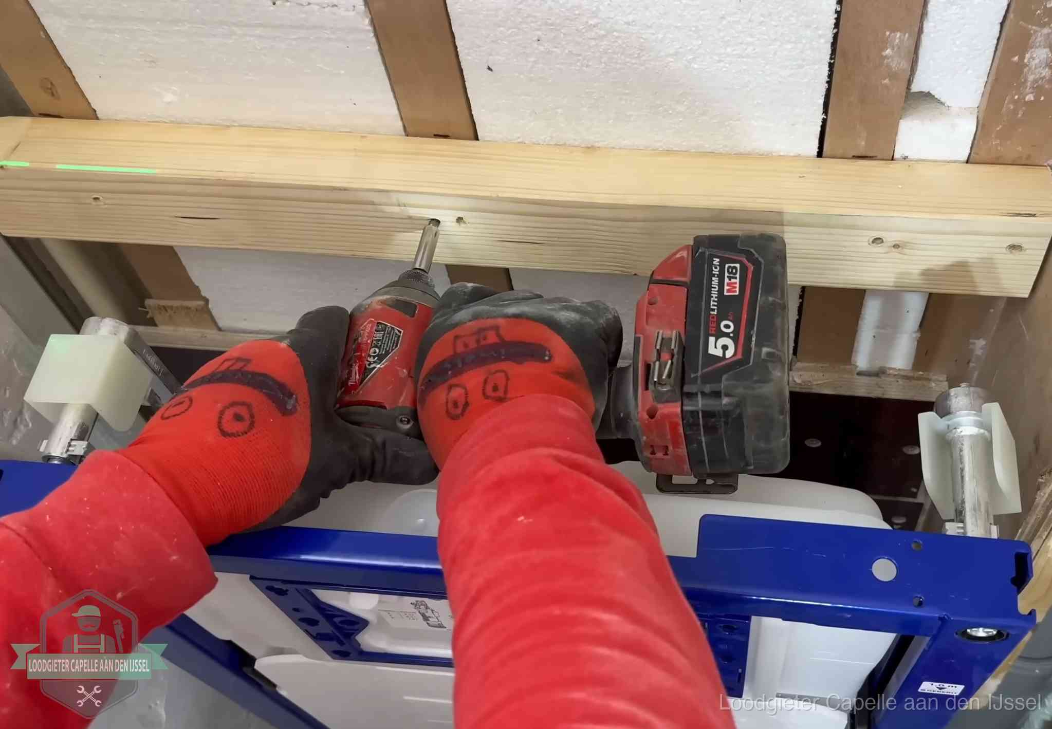 Monteur bevestigt een inbouwreservoir voor een hangend toilet in Capelle aan den IJssel