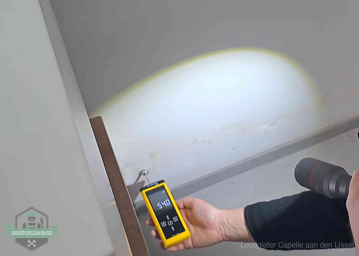 Vochtmeter tegen een natte wand met lekkagesporen in Capelle aan den IJssel