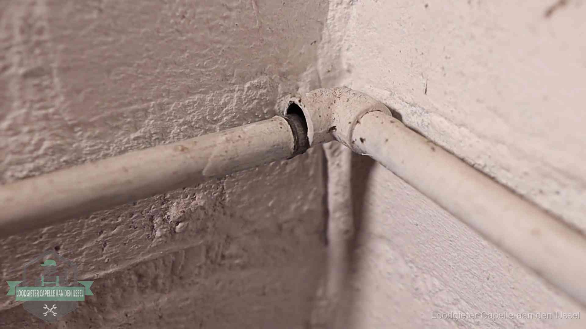 Oude geverfde waterleiding met een losliggende fitting in een woning in Capelle aan den IJssel
