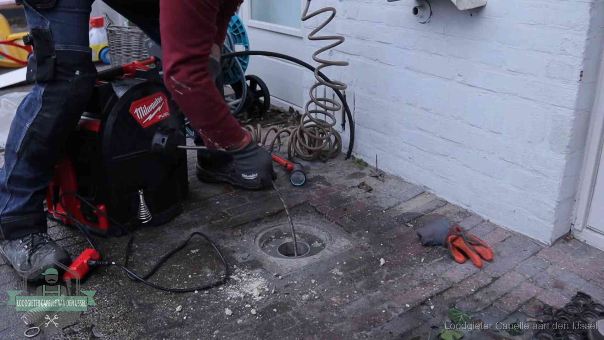 Spiraalmachine bij een ontstoppingsputje in de bestrating in Capelle aan den IJssel