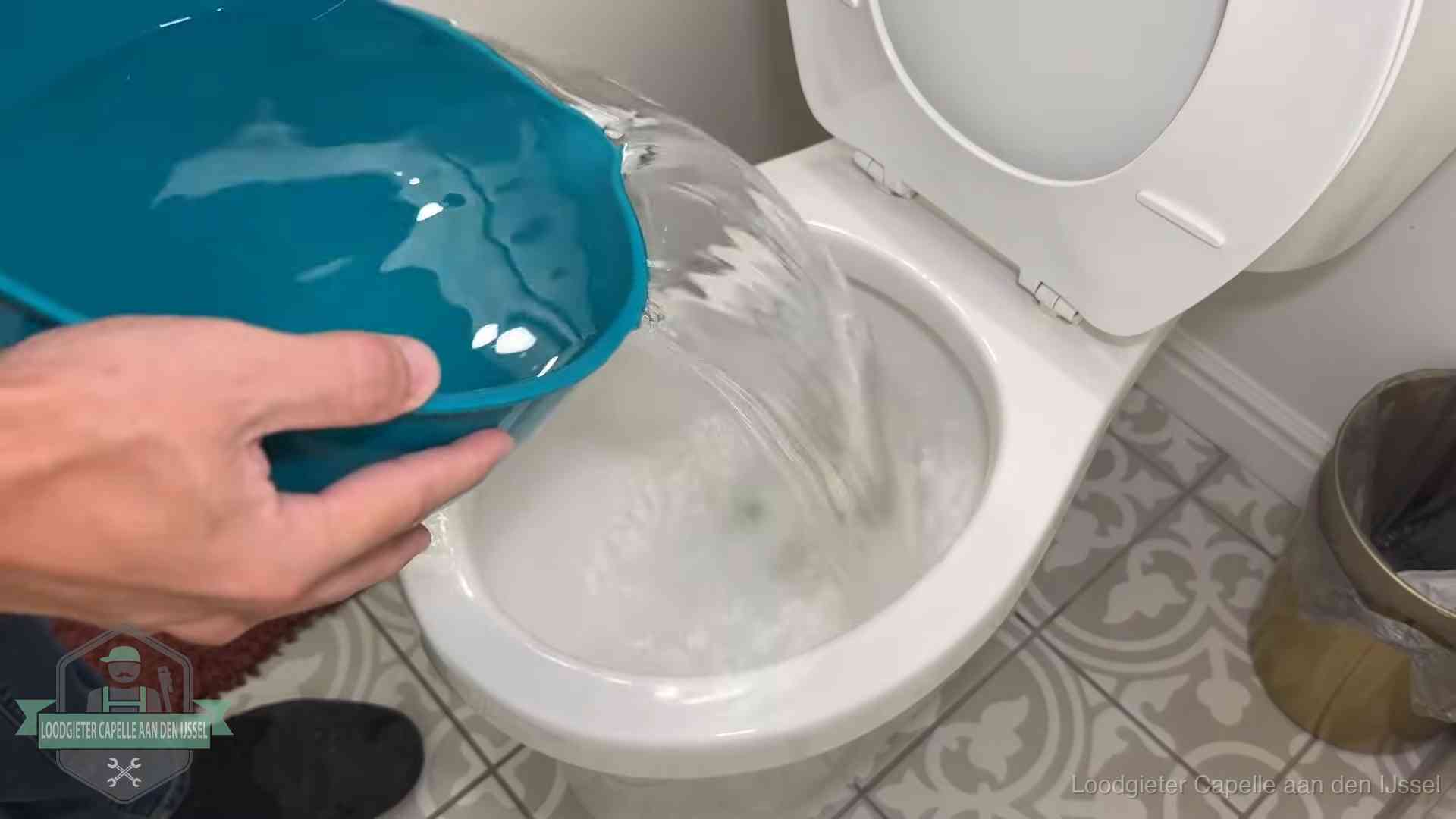 Warm water wordt voorzichtig in de wc-pot gegoten in Capelle aan den IJssel