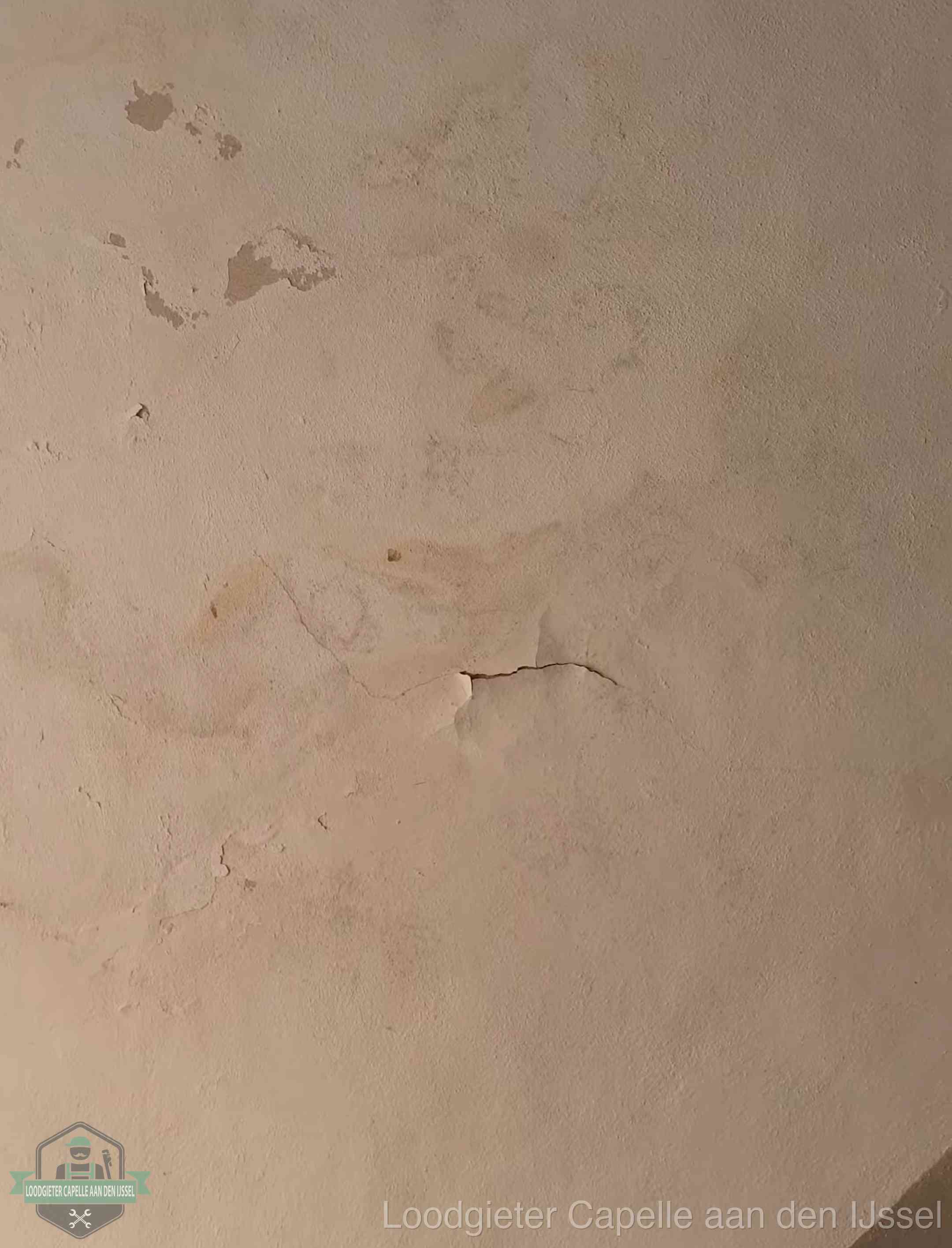 Vochtkringen en afbladderende verf op een plafond in Capelle aan den IJssel, schade voor het meetrapport en de verzekering