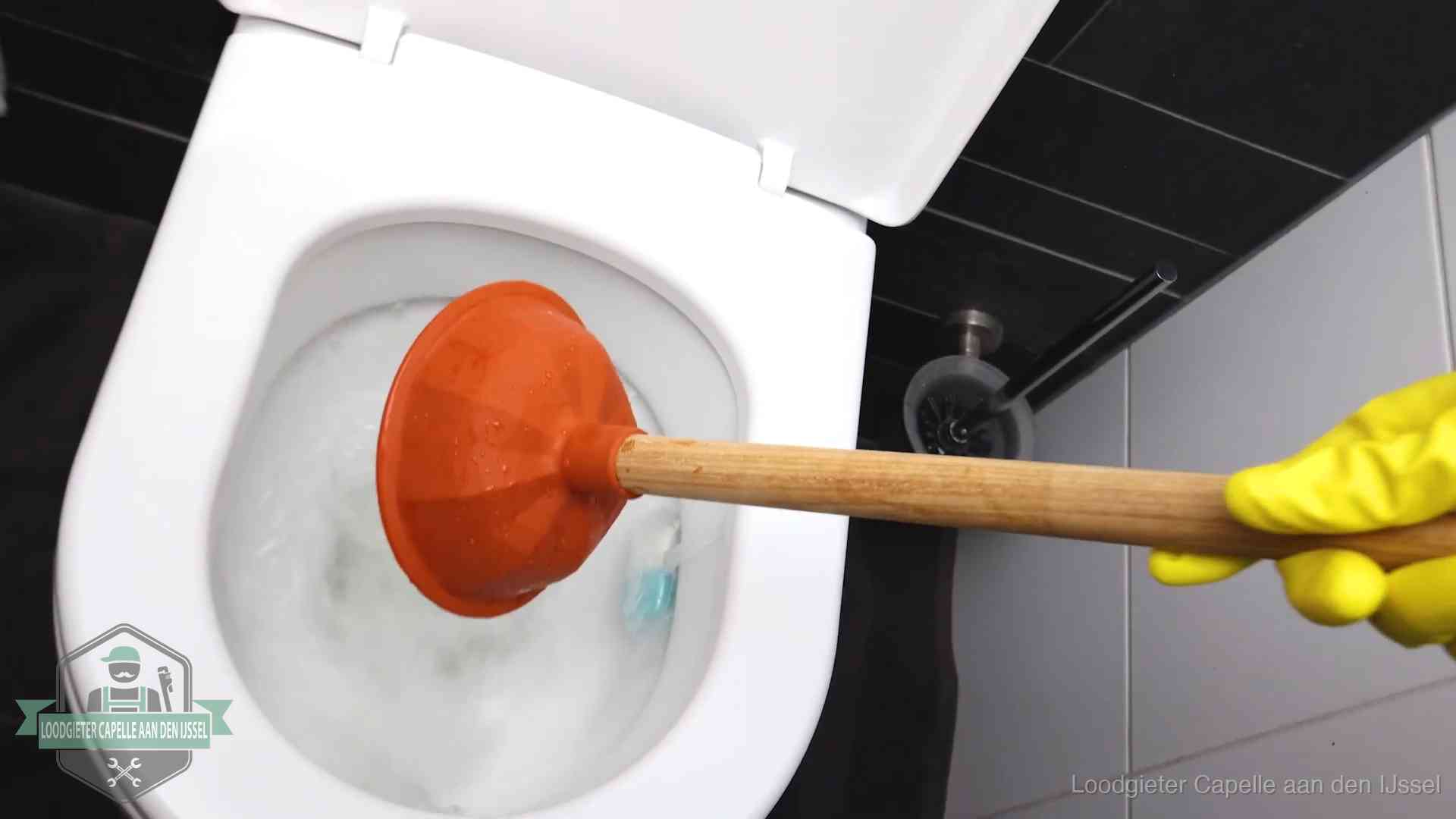 Plopper wordt in de wc-pot gedrukt bij het ontstoppen van een toilet in Capelle aan den IJssel